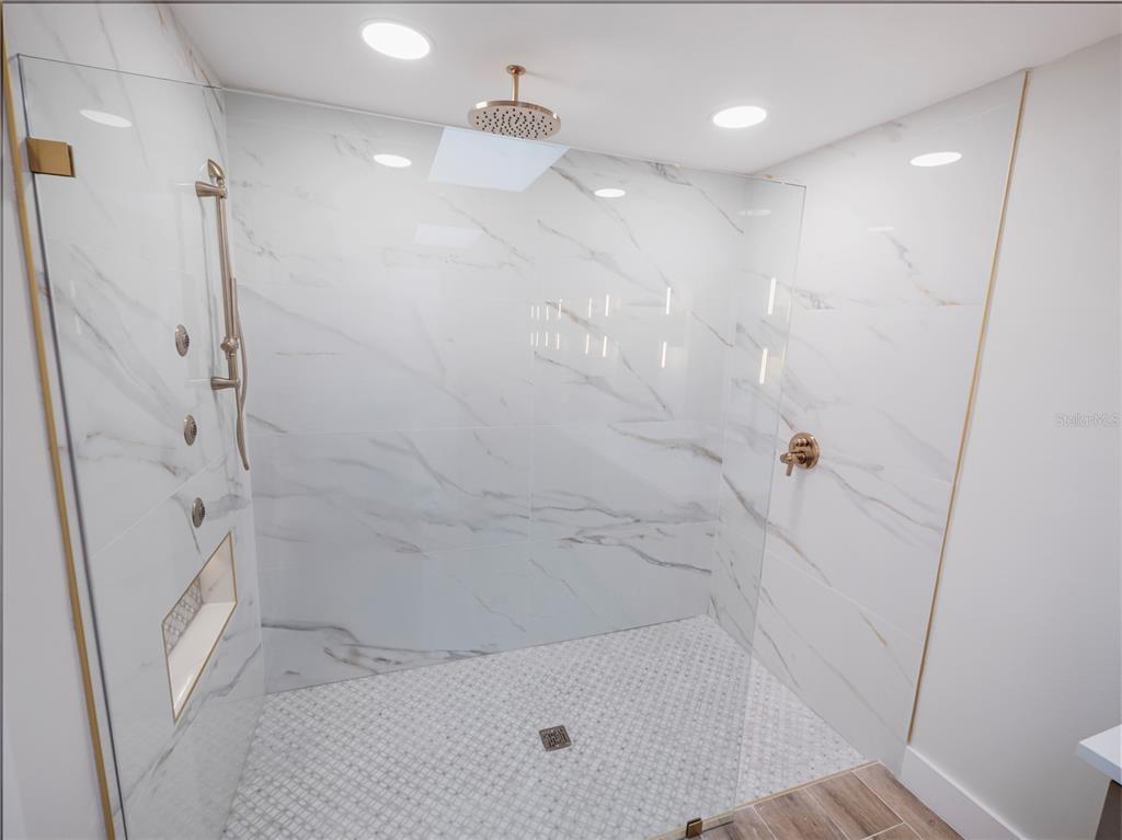 6790 Edgeworth Drive Orlando, FL 32819 - Photo 23 of 57 a bathroom with a bathtub and a shower