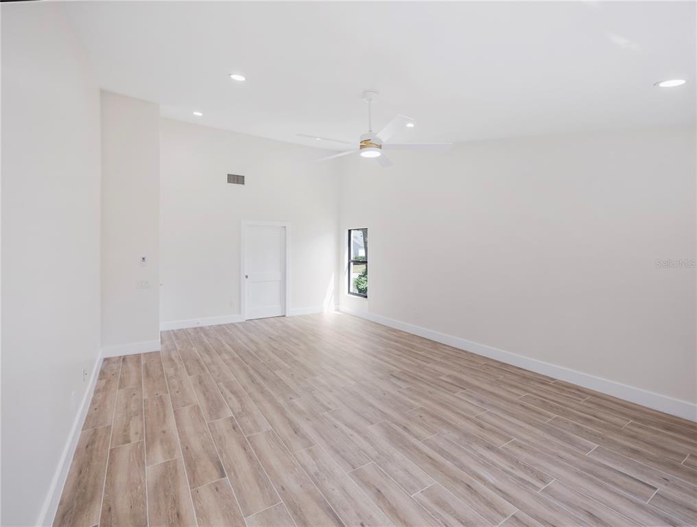 6790 Edgeworth Drive Orlando, FL 32819 - Photo 27 of 57 a view of empty room with wooden floor and fan