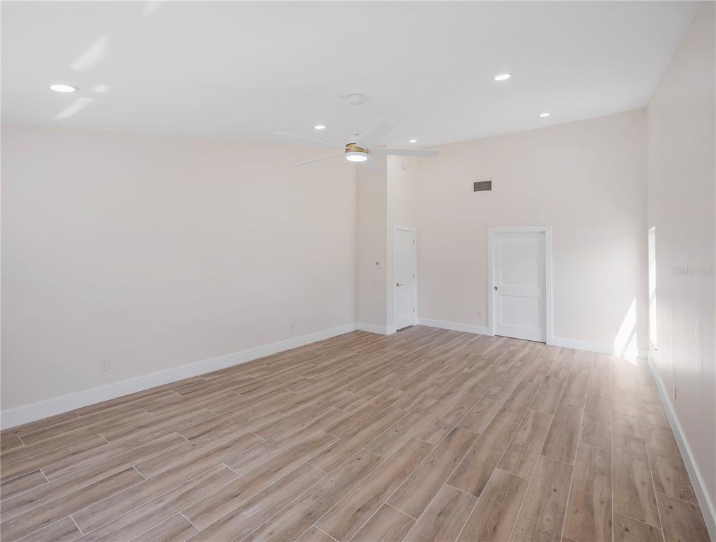 6790 Edgeworth Drive Orlando, FL 32819 - Photo 28 of 57 a view of empty room with wooden floor and fan