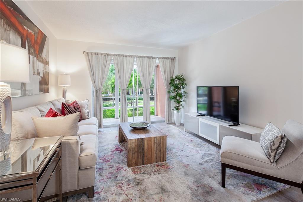72 7th Street South, Unit 208 Naples, FL 34102 - Photo 2 of 10 a living room with furniture and a flat screen tv