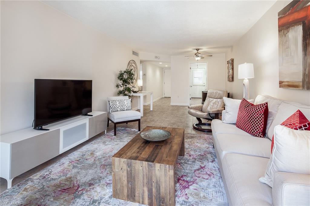 72 7th Street South, Unit 208 Naples, FL 34102 - Photo 3 of 10 a living room with furniture and a flat screen tv
