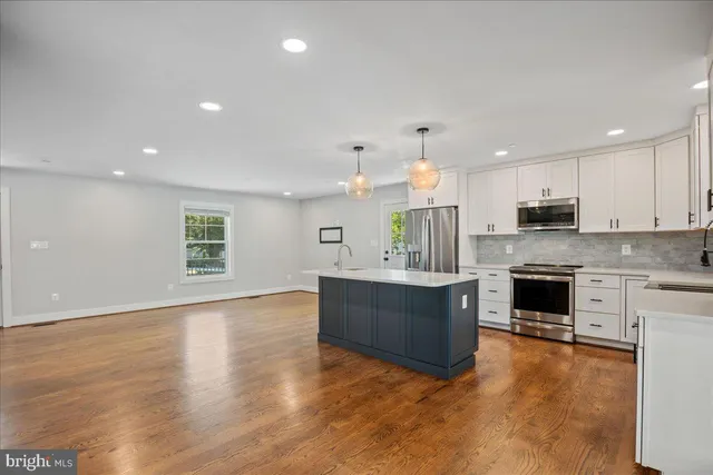 a kitchen with kitchen island granite countertop appliances cabinets and a counter space