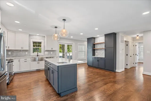 a kitchen with stainless steel appliances granite countertop a sink refrigerator and cabinets