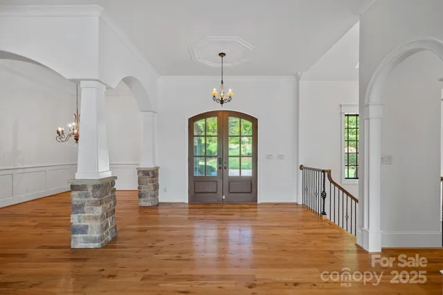 an empty room with wooden floor and ceiling fan