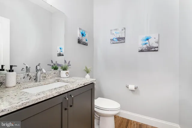 a bathroom with a granite countertop sink mirror and toilet