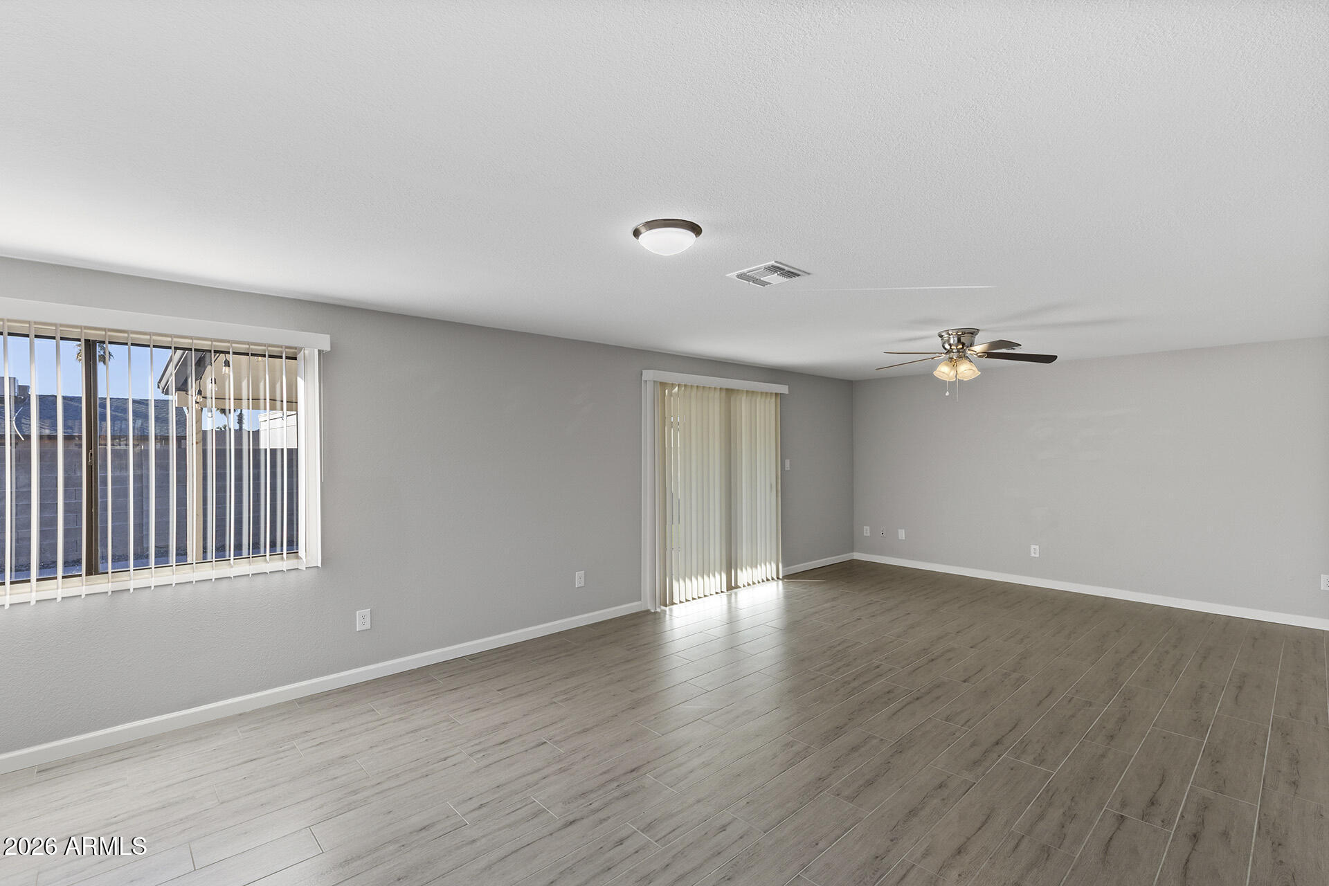 3749 East Pershing Avenue Phoenix, AZ 85032 - Photo 19 of 53 a view of an empty room with a window and wooden floor