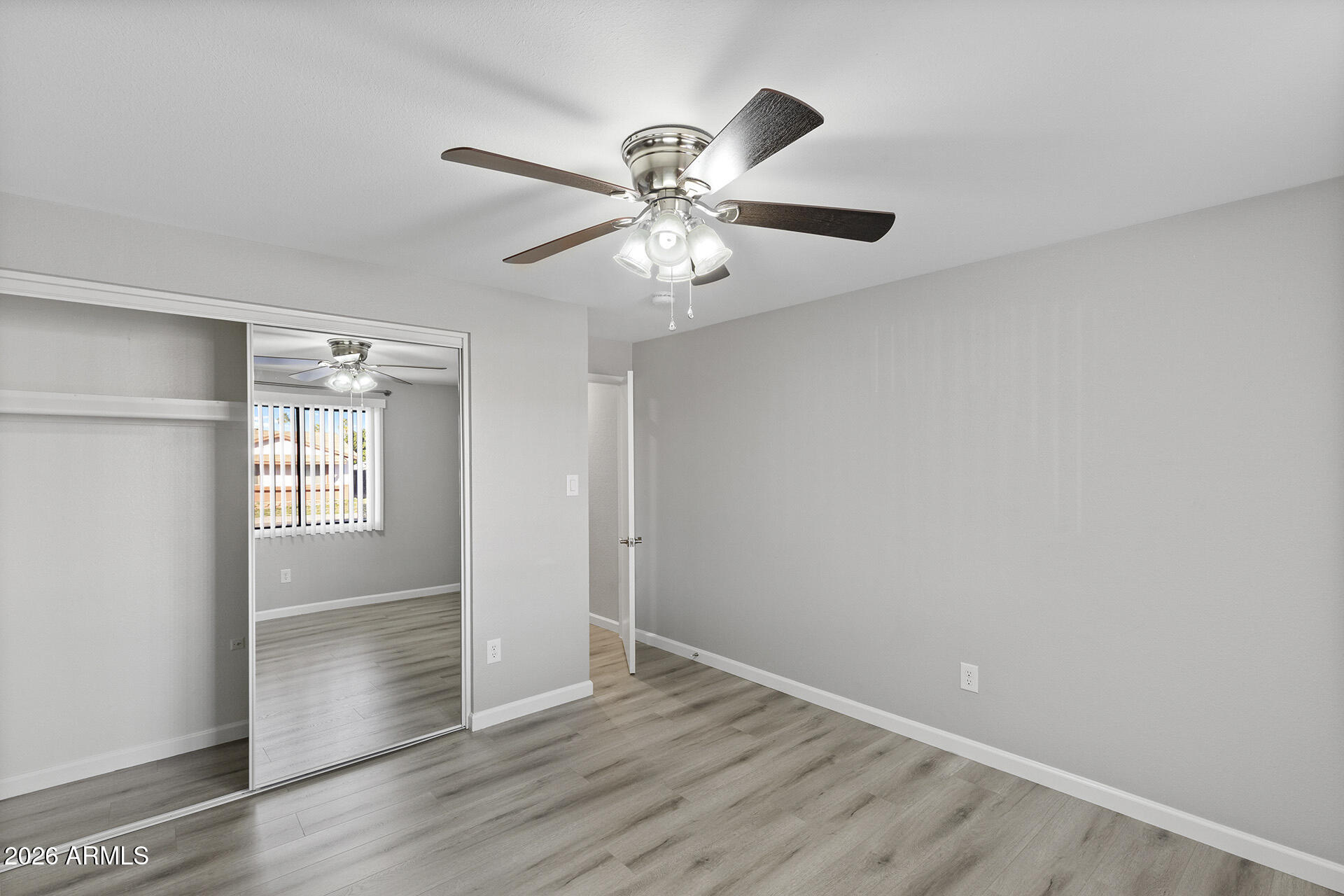 3749 East Pershing Avenue Phoenix, AZ 85032 - Photo 35 of 53 an empty room with wooden floor chandelier fan and windows