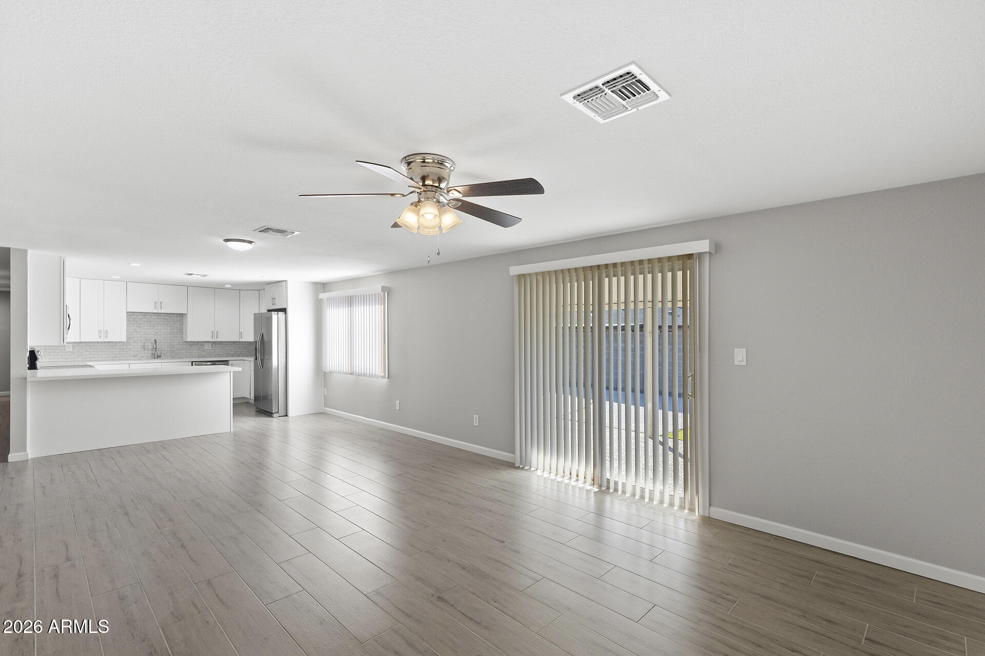 3749 East Pershing Avenue Phoenix, AZ 85032 - Photo 3 of 53 a view of an empty room with wooden floor and a window