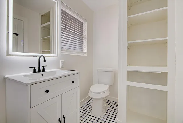 a bathroom with a sink toilet and window