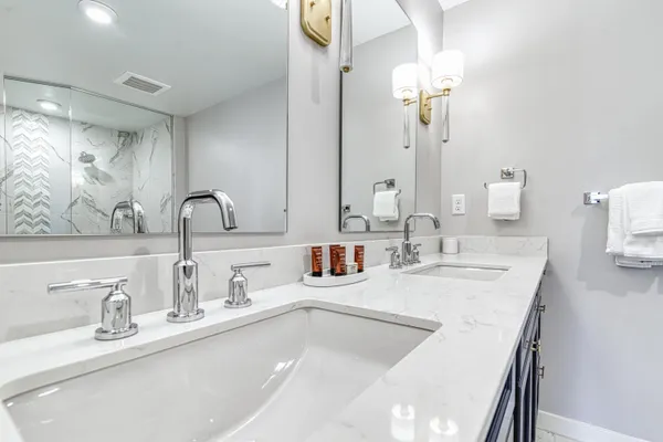 a bathroom with double sink and a mirror