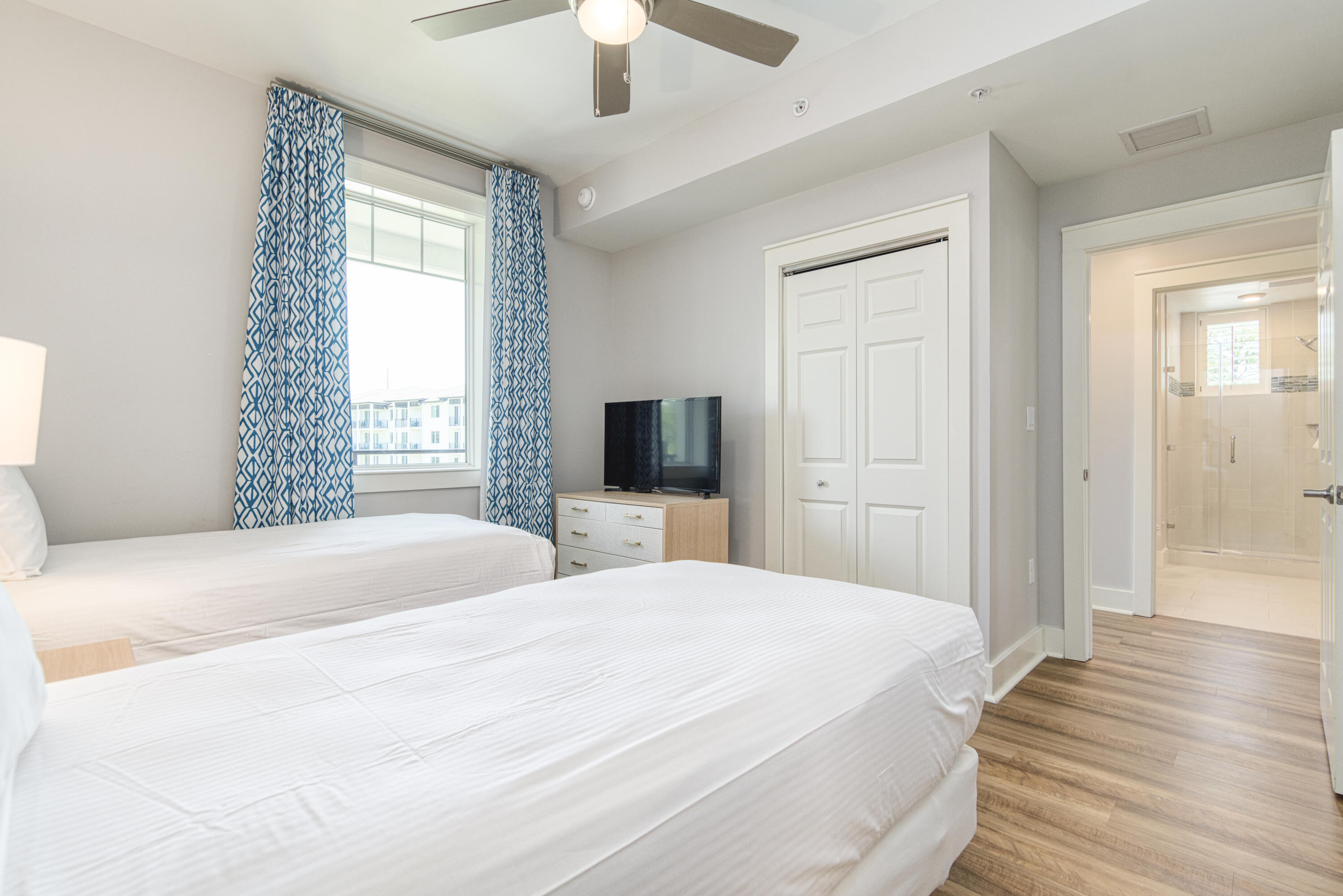 9000 Heron Walk Drive, Unit 3204 Miramar Beach, FL 32550 - Photo 27 of 45 a spacious bedroom with a bed and a flat tv screen on dresser