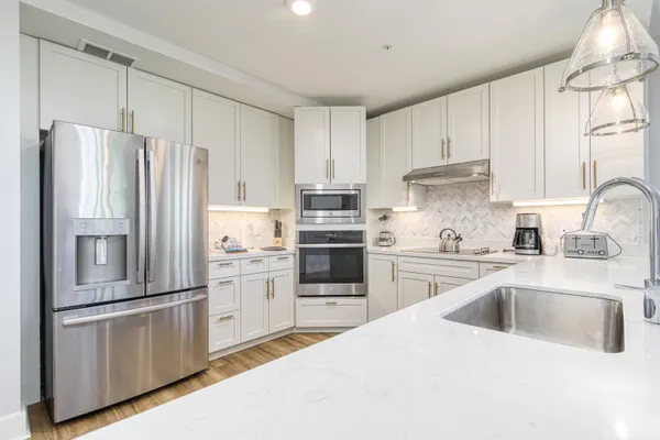 a kitchen with stainless steel appliances white cabinets and a refrigerator