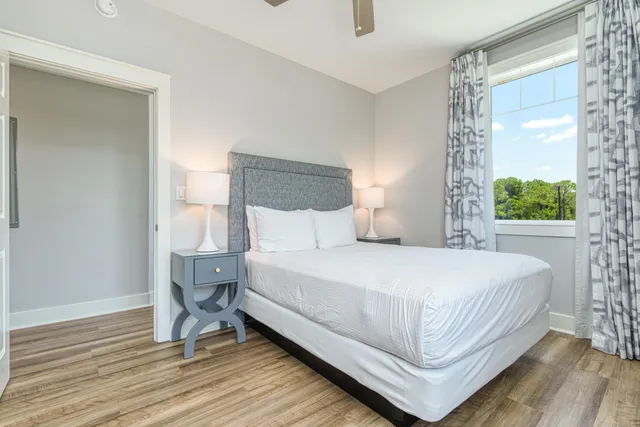 a bedroom with a large bed and a flat tv screen on dresser