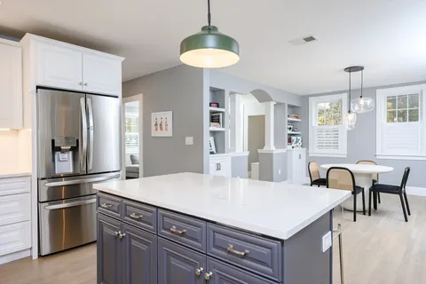 a kitchen with stainless steel appliances a table chairs and refrigerator