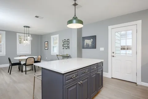 a view of a kitchen area with furniture and wooden floor