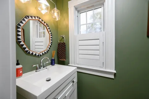 a bathroom with a sink a mirror and a window