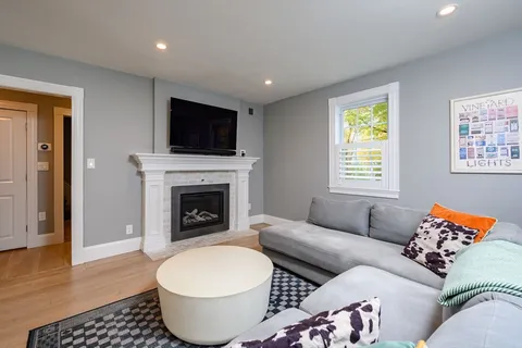 a living room with furniture a flat screen tv and a fireplace
