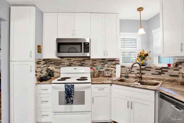 a kitchen with appliances a sink and cabinets