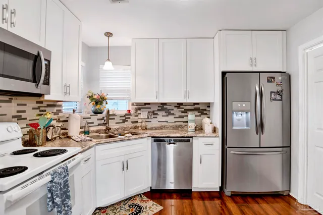 a kitchen with stainless steel appliances a refrigerator sink and microwave