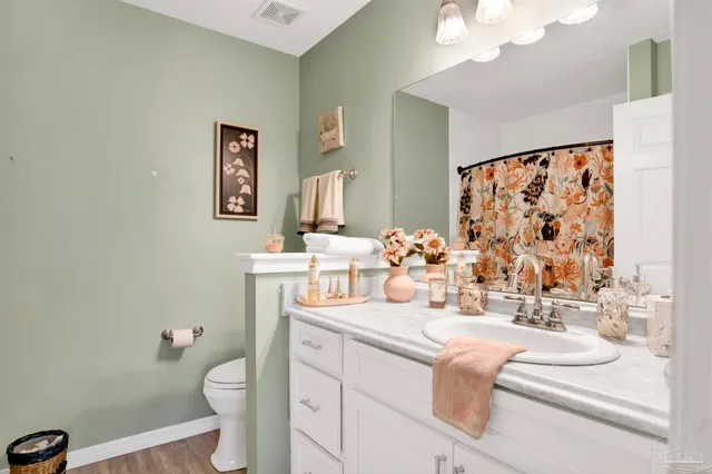 a bathroom with a sink vanity mirror and toilet