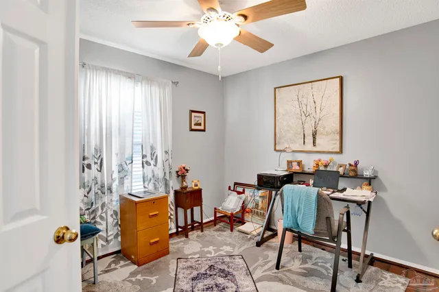 a view of a workspace with furniture and a window