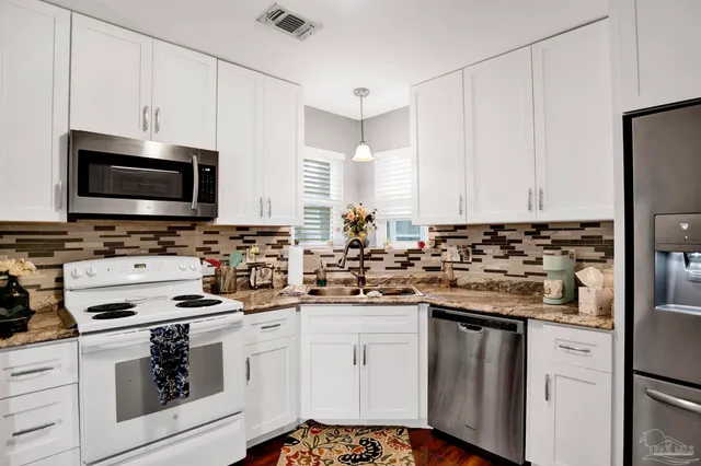 a kitchen with appliances a sink and cabinets