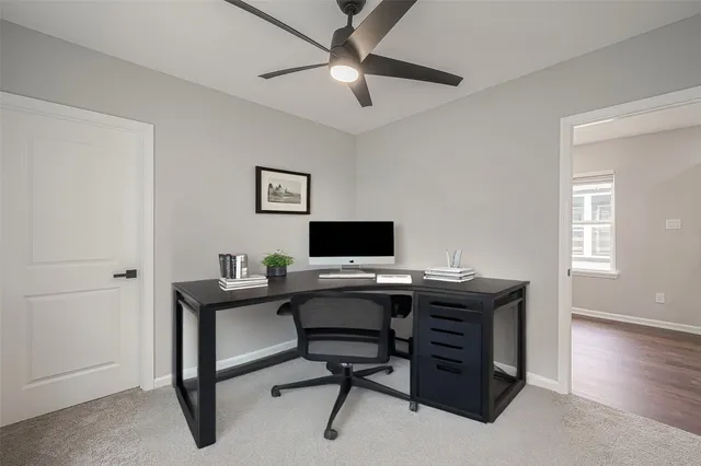 an empty room with a window and a fan