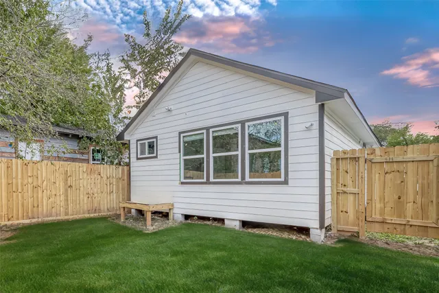 a view of backyard with potted plants and wooden fence