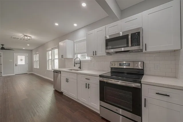 a kitchen with stainless steel appliances granite countertop a stove microwave and sink