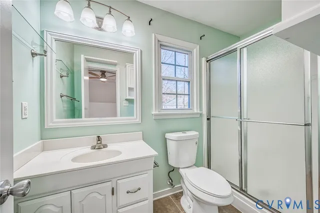 a bathroom with a toilet a sink a mirror and a shower