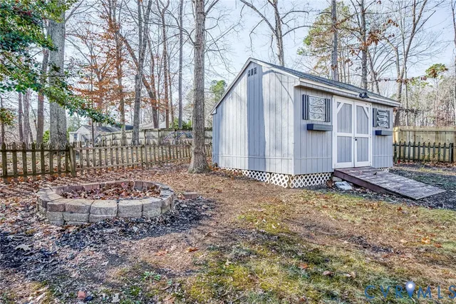 a backyard of a house with a bench and trees