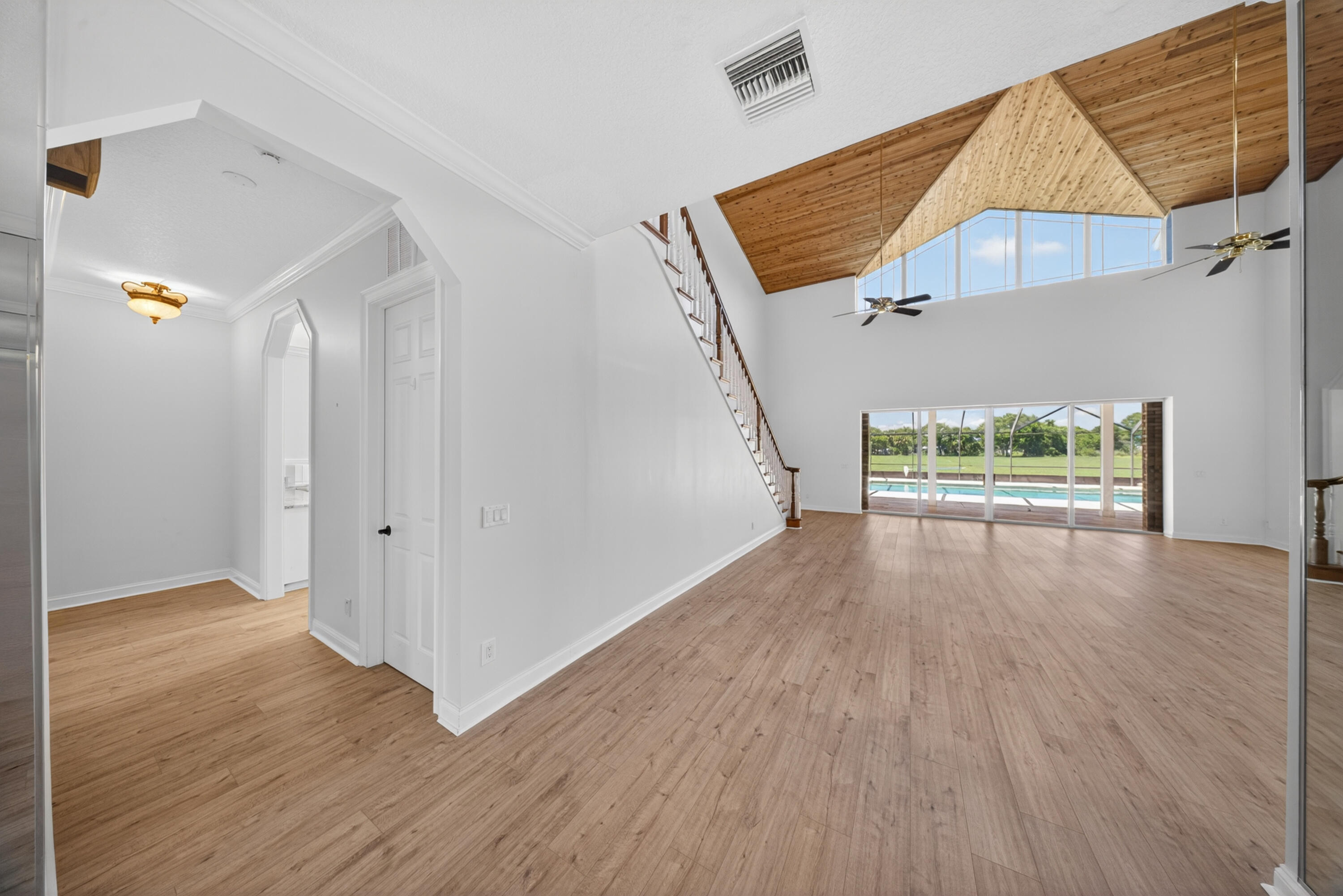 8686 Andrews Avenue Fort Pierce, FL 34945 - Photo 5 of 76 a view of an empty room with wooden floor and a window