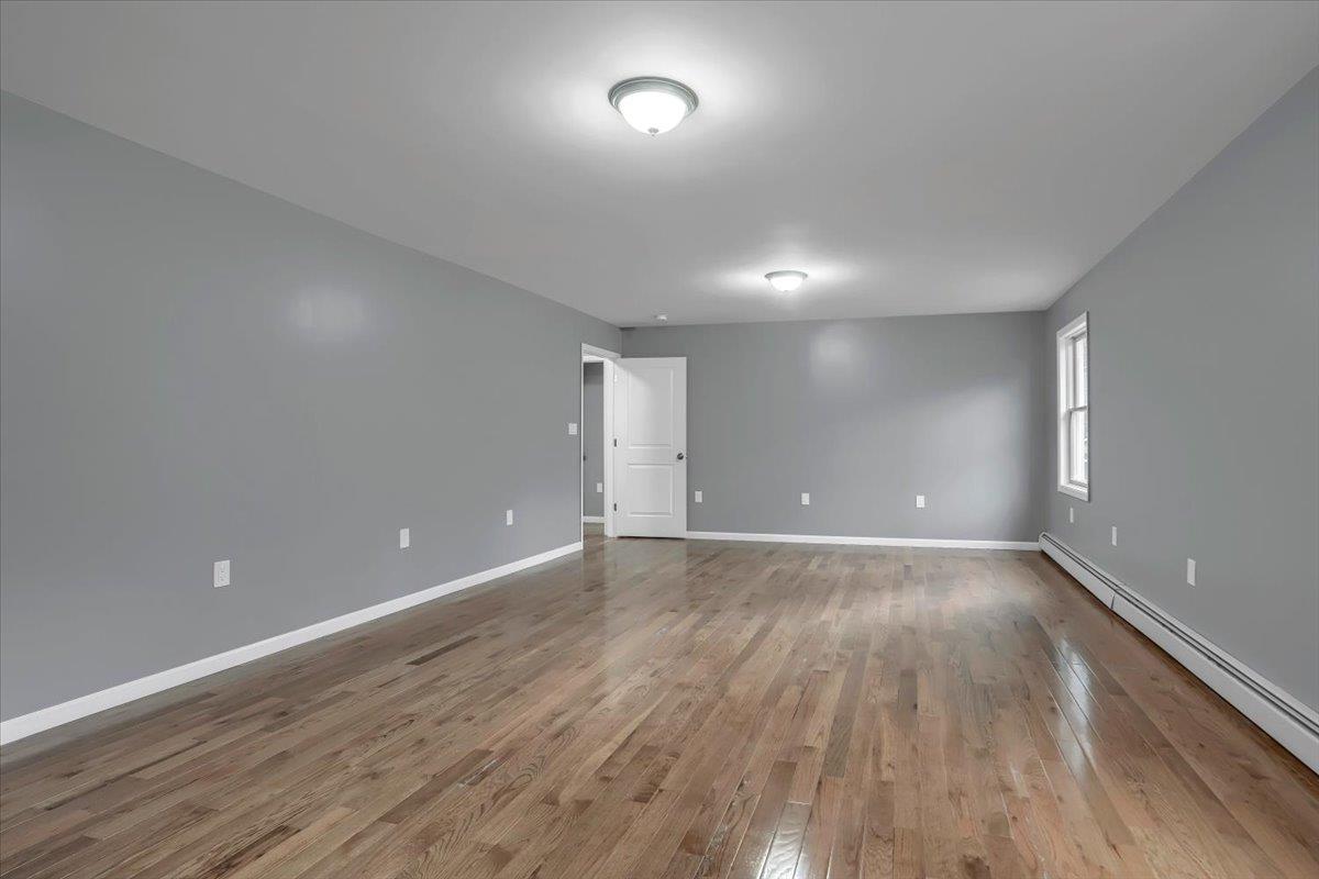 279 Mountain Lodge Road Monroe, NY 10950 - Photo 1 of 1 Unfurnished room with a baseboard heating unit, wood finished floors, and baseboards