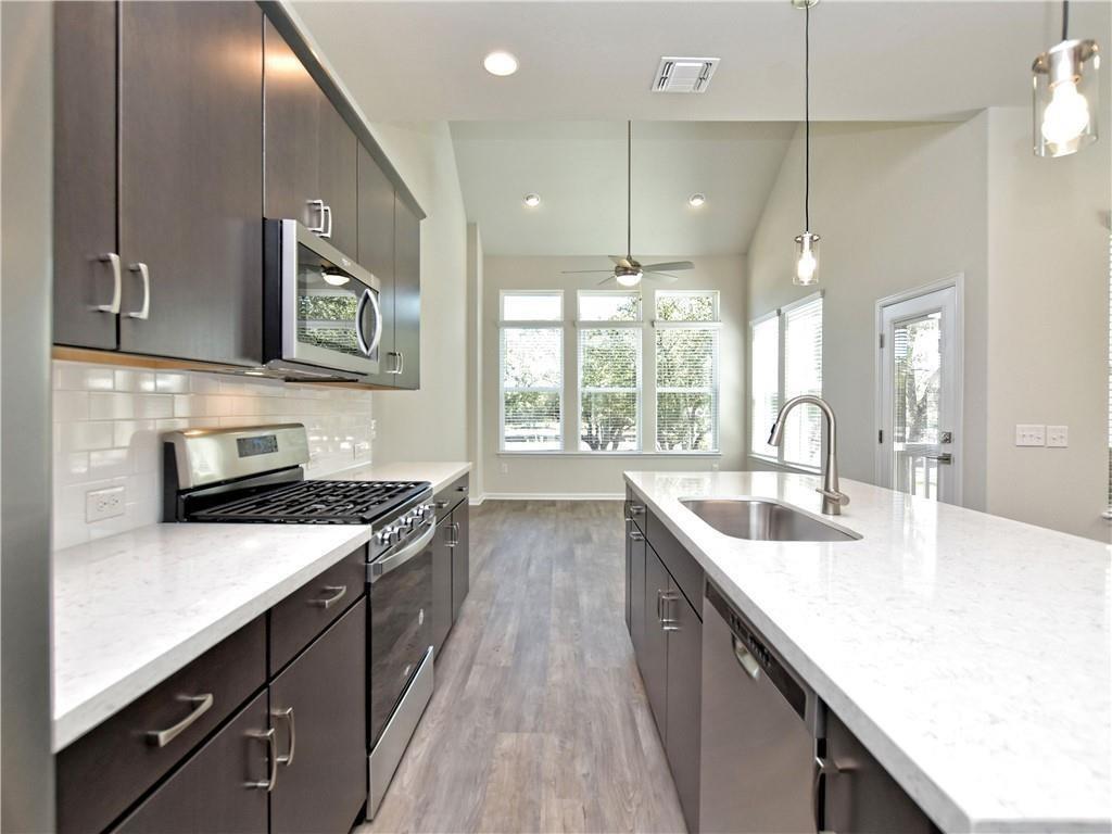 13611 Terrett Trace, Unit 108 Austin, TX 78717 - Photo 14 of 33 a kitchen with granite countertop a sink a counter space appliances and cabinets