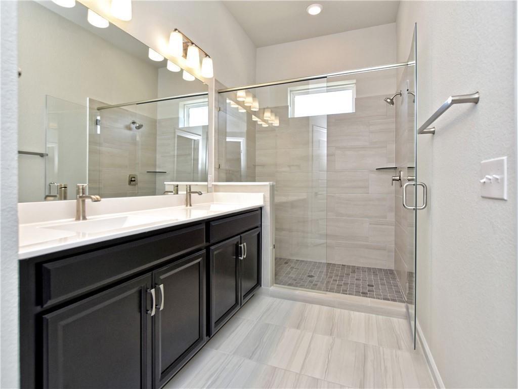 13611 Terrett Trace, Unit 108 Austin, TX 78717 - Photo 20 of 33 a bathroom with a double vanity sink mirror and shower