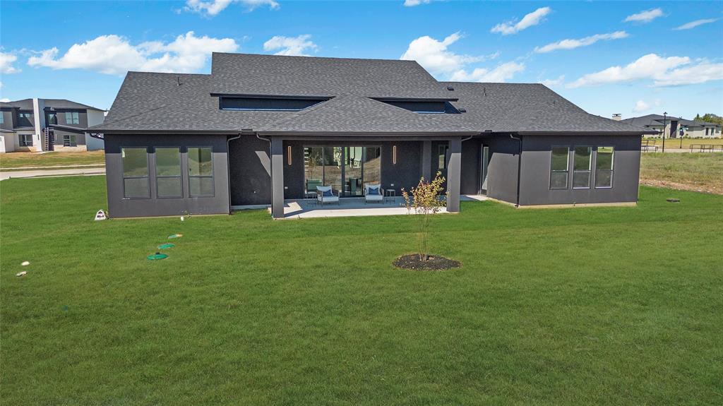 430 Whispering Way Red Oak, TX 75154 - Photo 8 of 40 Contemporary rear exterior featuring dark stucco siding, a covered patio, and large sliding glass doors