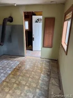 a view of a hallway with wooden floor and a large mirror