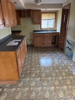 a kitchen with granite countertop a stove a sink and a refrigerator