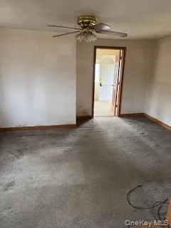 a view of a livingroom with a ceiling fan and wooden floor