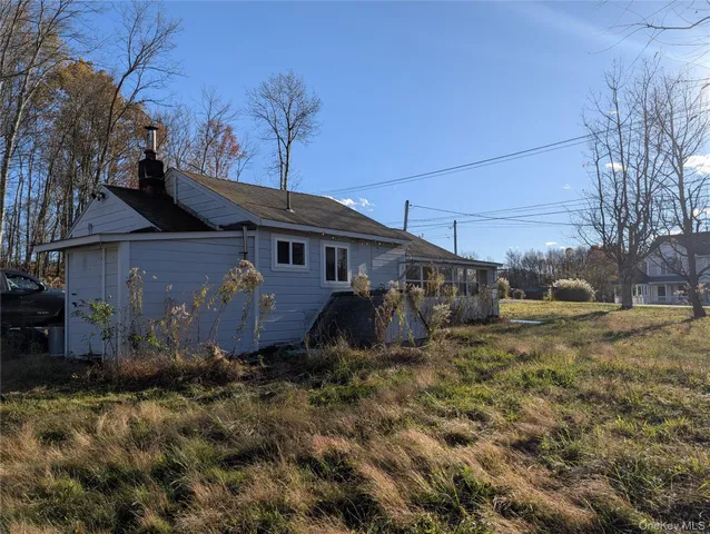 a view of a house with backyard and trees