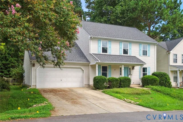 a front view of a house with a yard and a garage