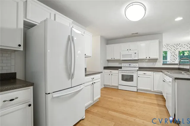 a kitchen with white cabinets and white appliances