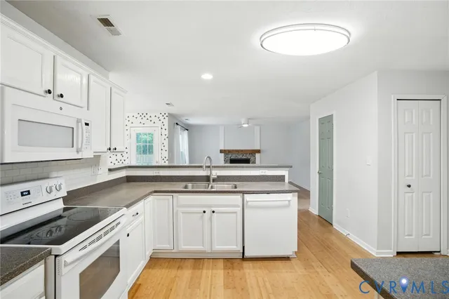 a kitchen with a sink cabinets and wooden floor