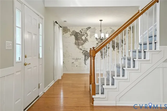 a view of staircase with lots of frames on wall and windows