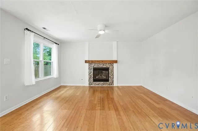 a view of an empty room with a fireplace and a window