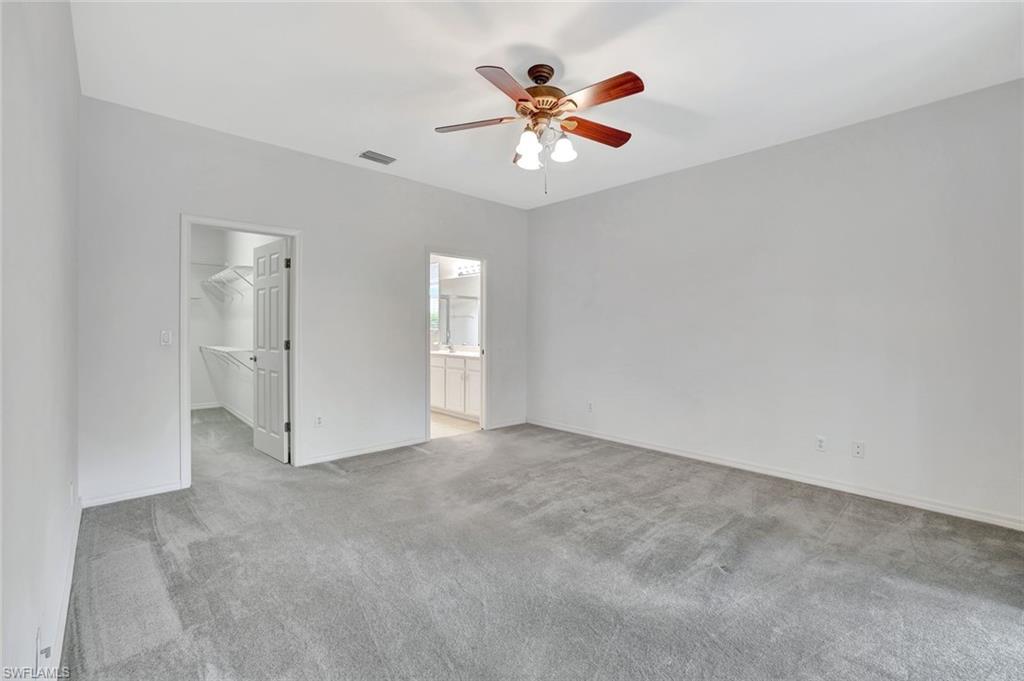 3617 Recreation Lane Naples, FL 34116 - Photo 13 of 25 an empty room with chandelier fan and closet area