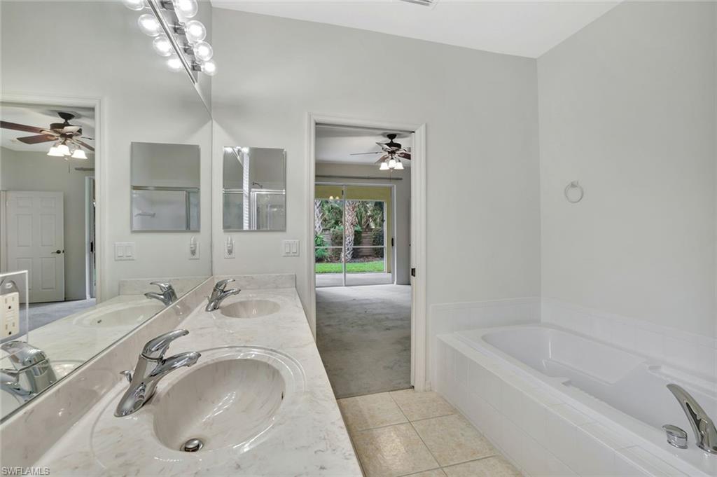 3617 Recreation Lane Naples, FL 34116 - Photo 17 of 25 a bathroom with a tub sink and mirror