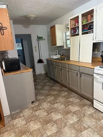 a room with furniture a flat screen tv and a refrigerator