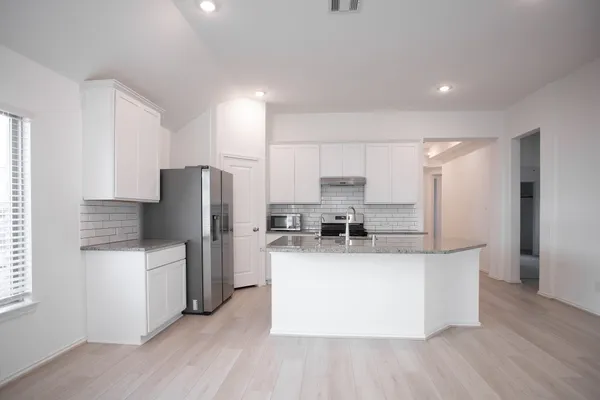 a kitchen with stainless steel appliances a refrigerator and a stove top oven