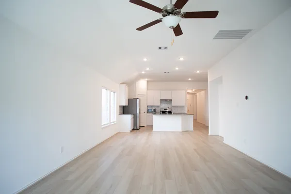 a large white kitchen with a white countertops with wooden floor